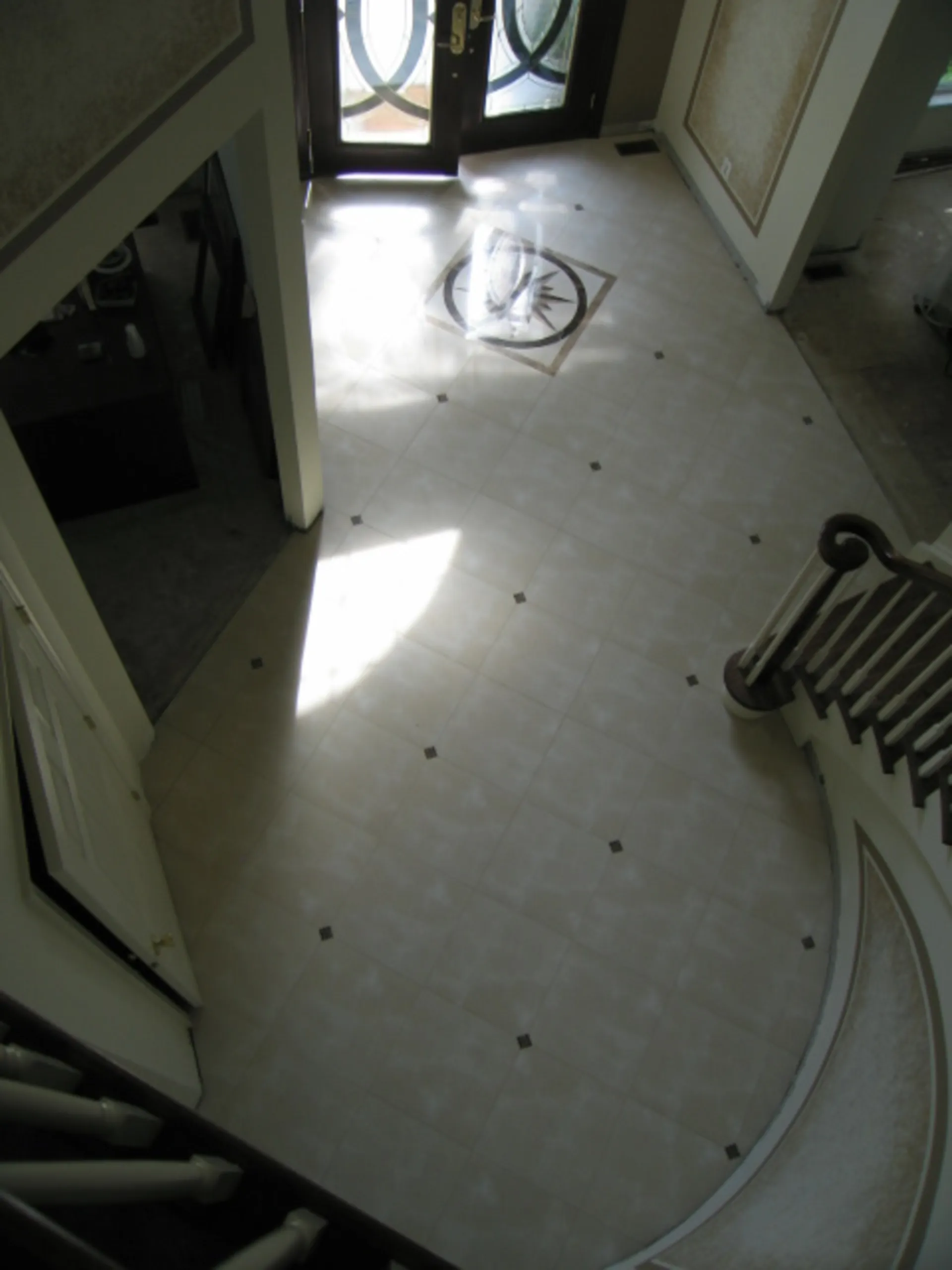 Foyer - Large foyer with tile inlays featuring a spiral staircase