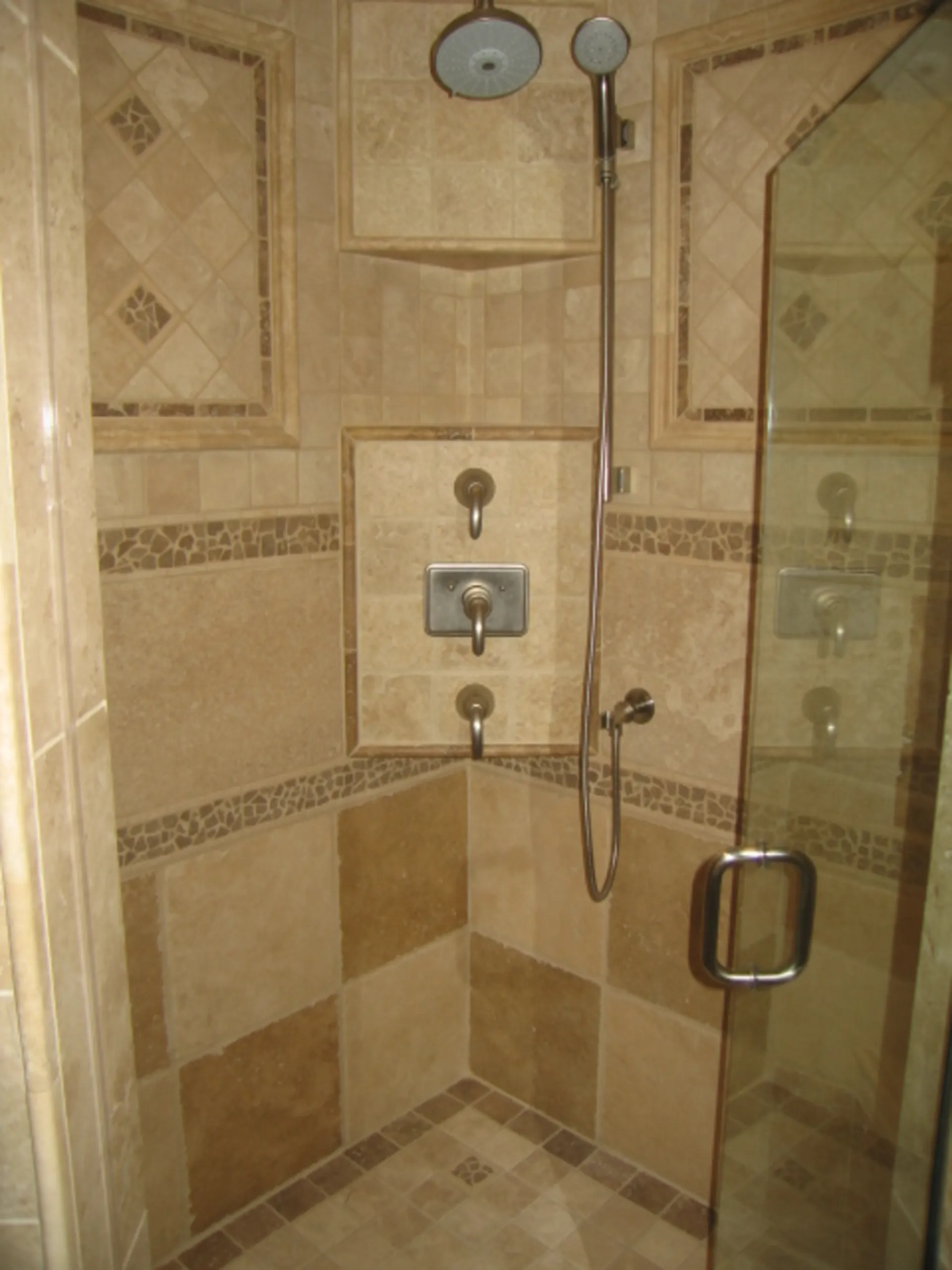 Master Bath - Inside shower view of custom bath with natural stone, jets, tile inlays, shelves, accents