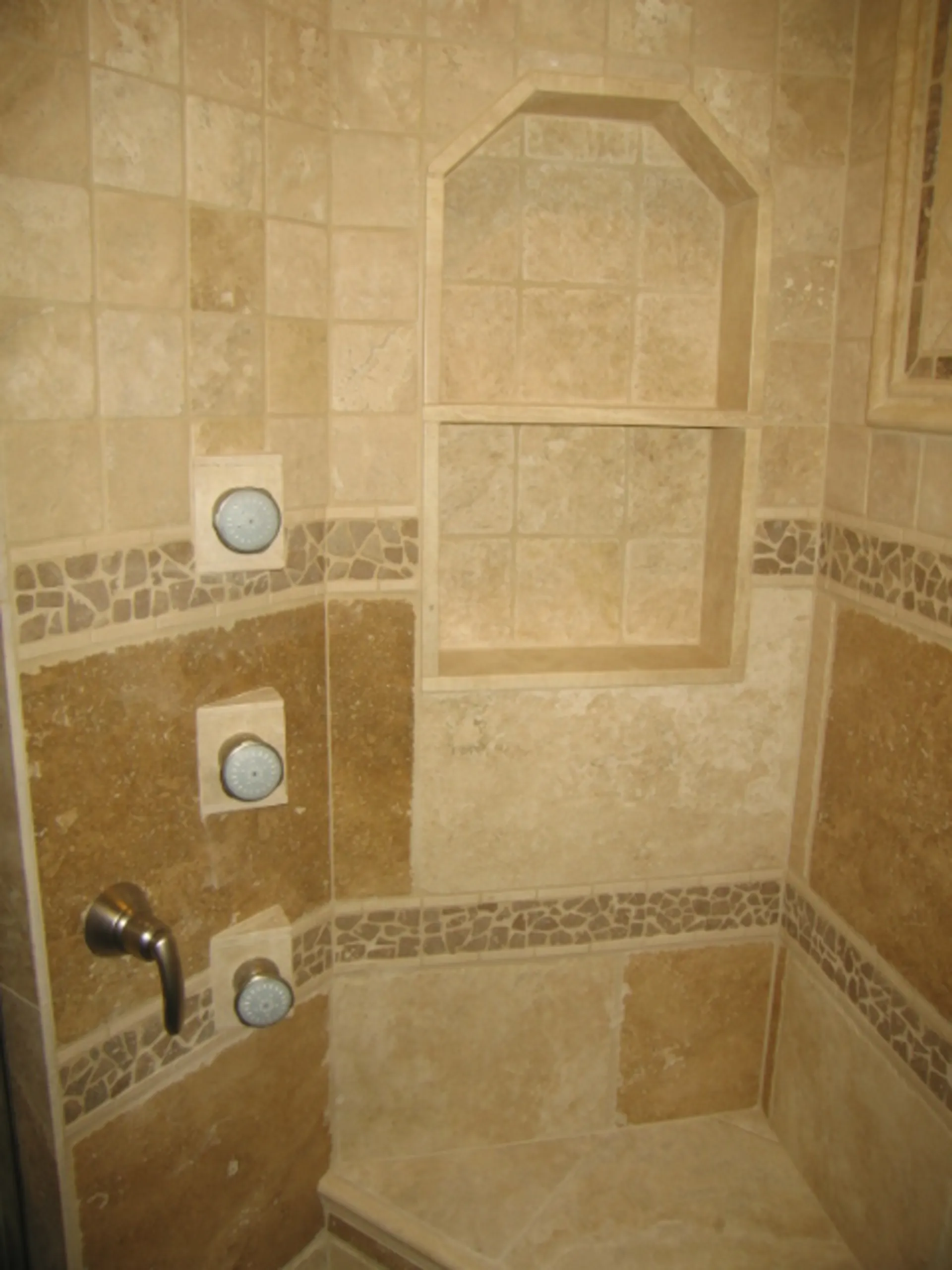 Master Bath - Right-side view of shower in custom bath with natural stone, jets, niches, tile inlays