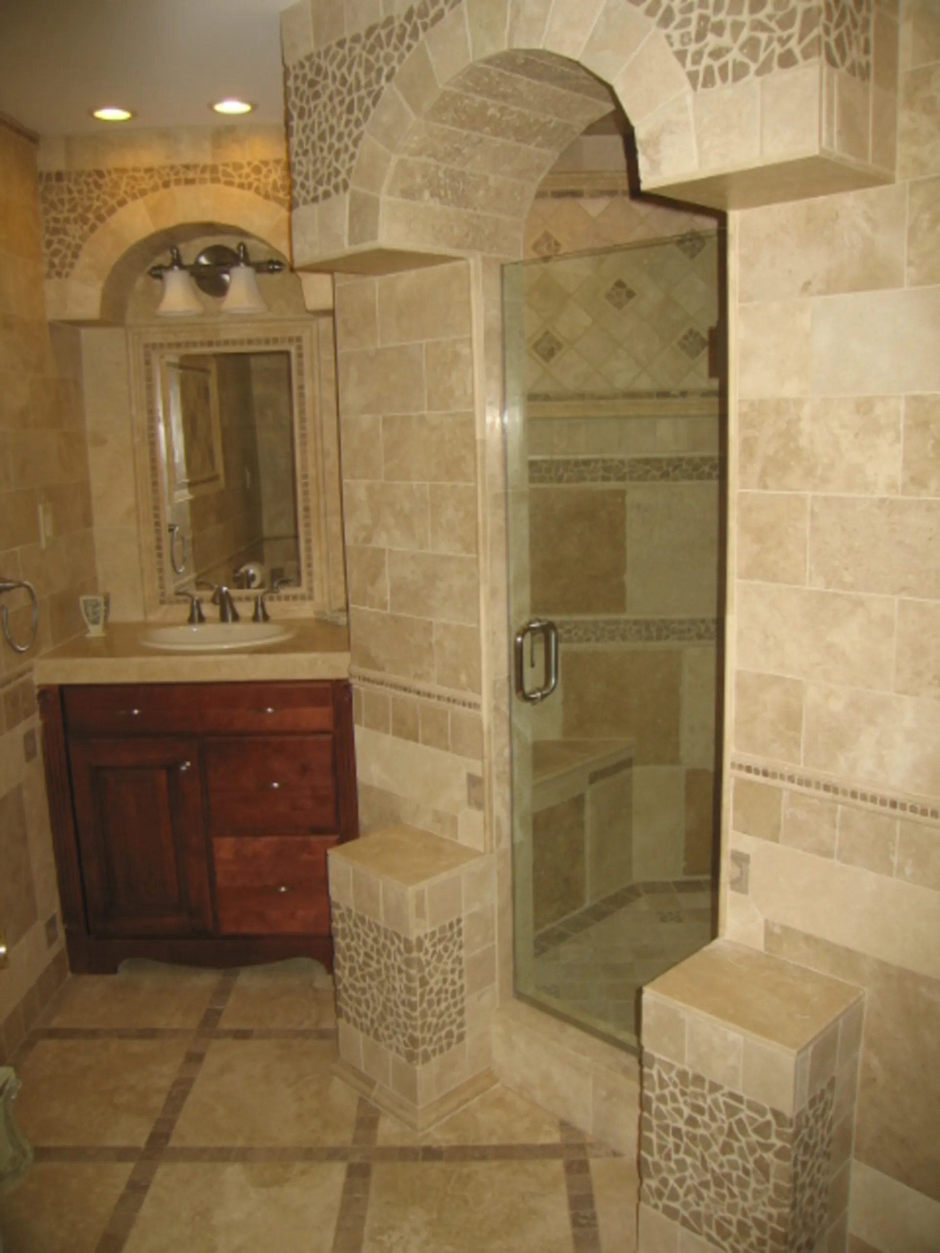 Master Bath - Wide view of custom bath with natural stone, jets, niches, tile inlays, custom tile mirror surrounds, and custom tile vanity tops