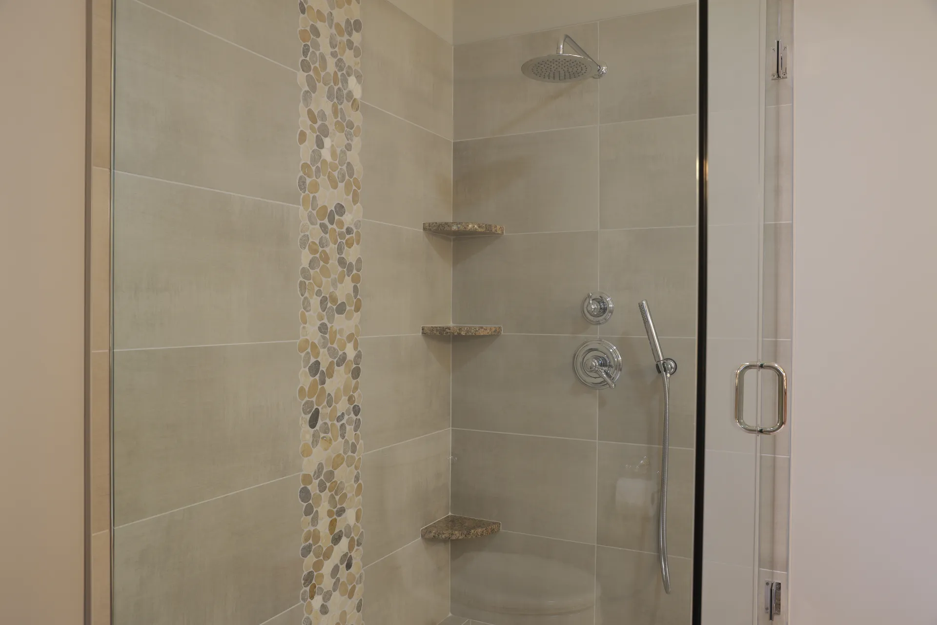 Master Bath – Inside view of frameless shower with large format tile walls, custom large format shower pan, and built-in shelves