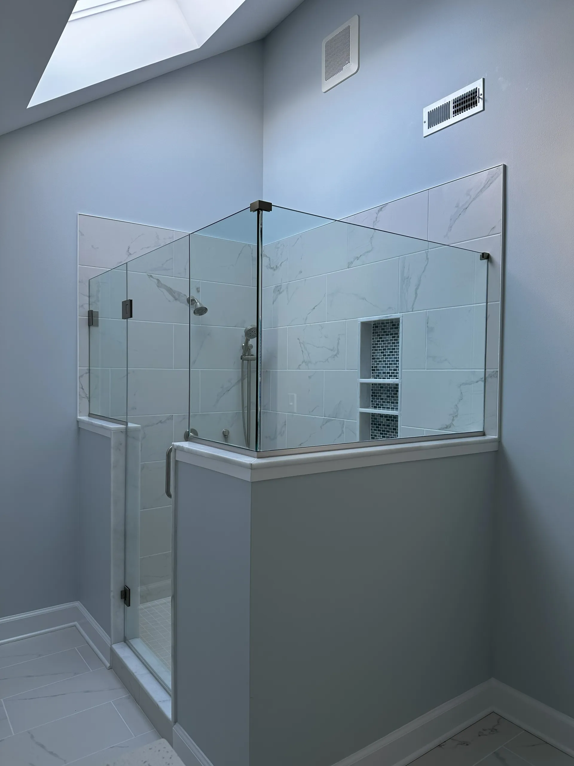 Master Bath - Close-up view of pony walls with frameless shower door and custom niche