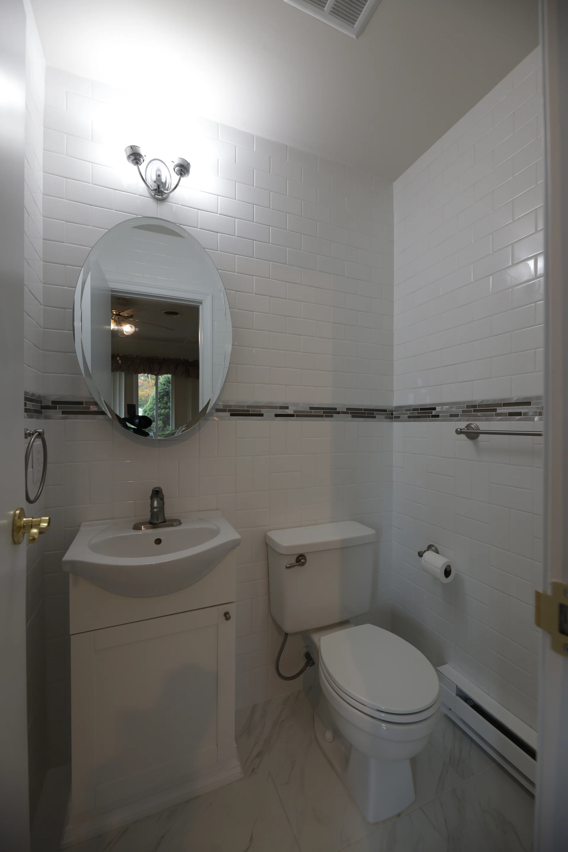  Powder Room - One-third offset floor tile, horizontal accent line on wall tile to the ceiling, with vanity and toilet